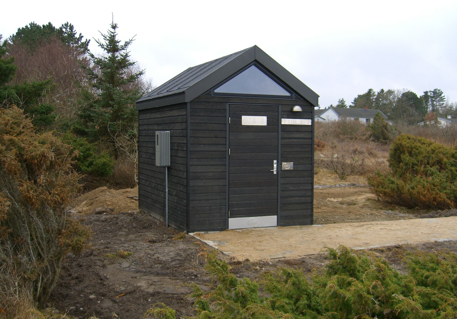 Et lille sort skur midt på en mark