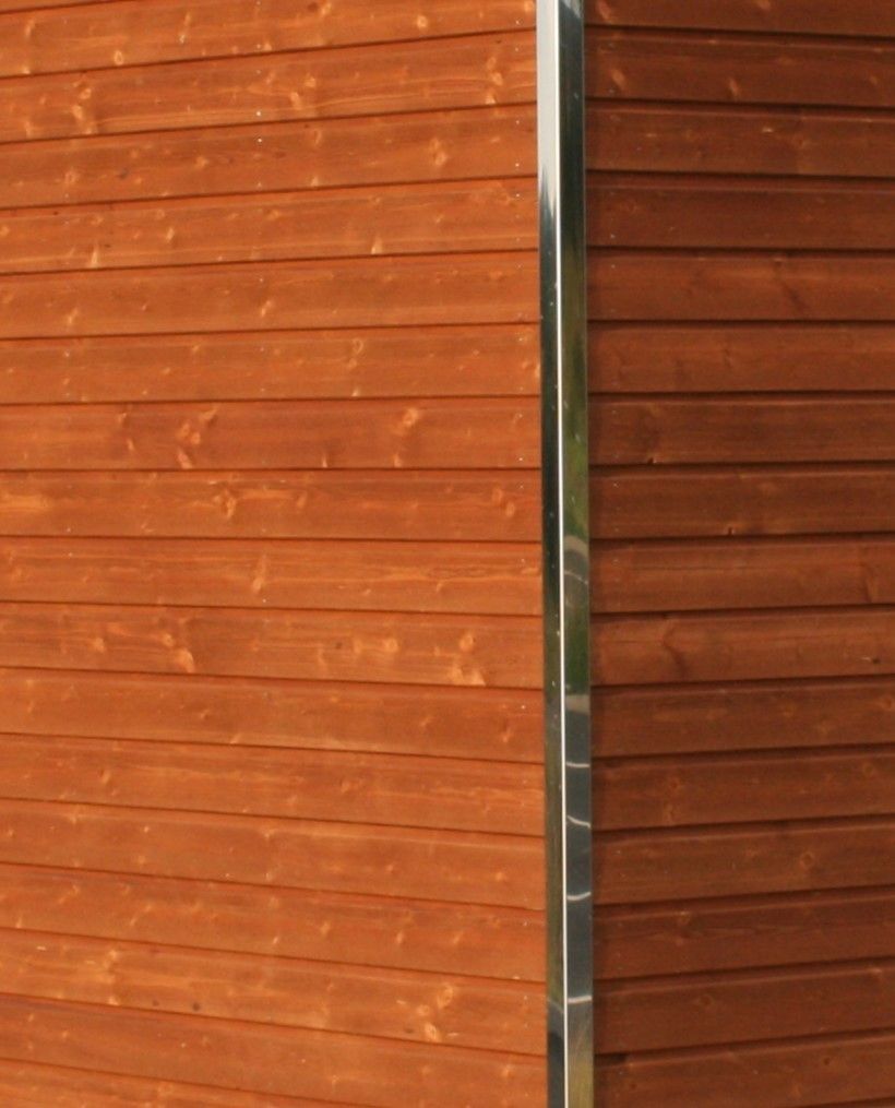 Et nærbillede af en trævæg med metalbeklædning