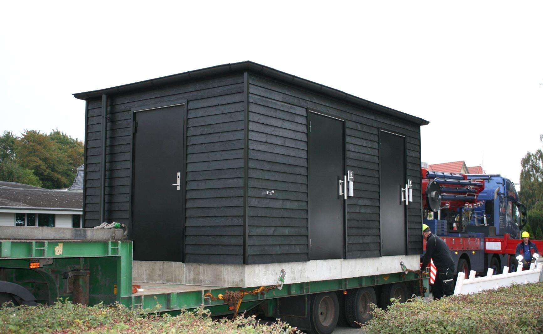 En lastbil transporterer et lille hus på en trailer