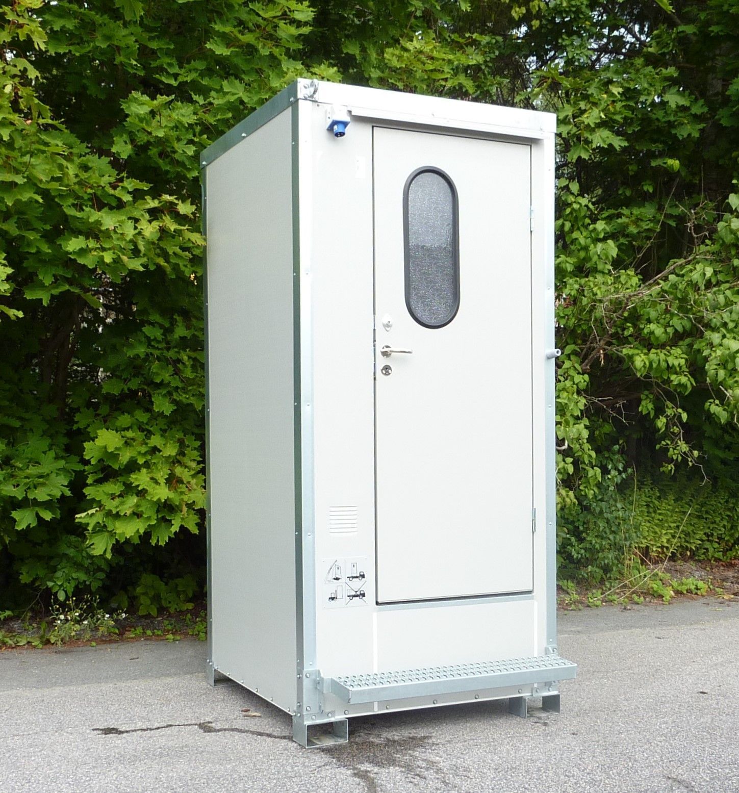 En lille hvid bygning med dør og vindue