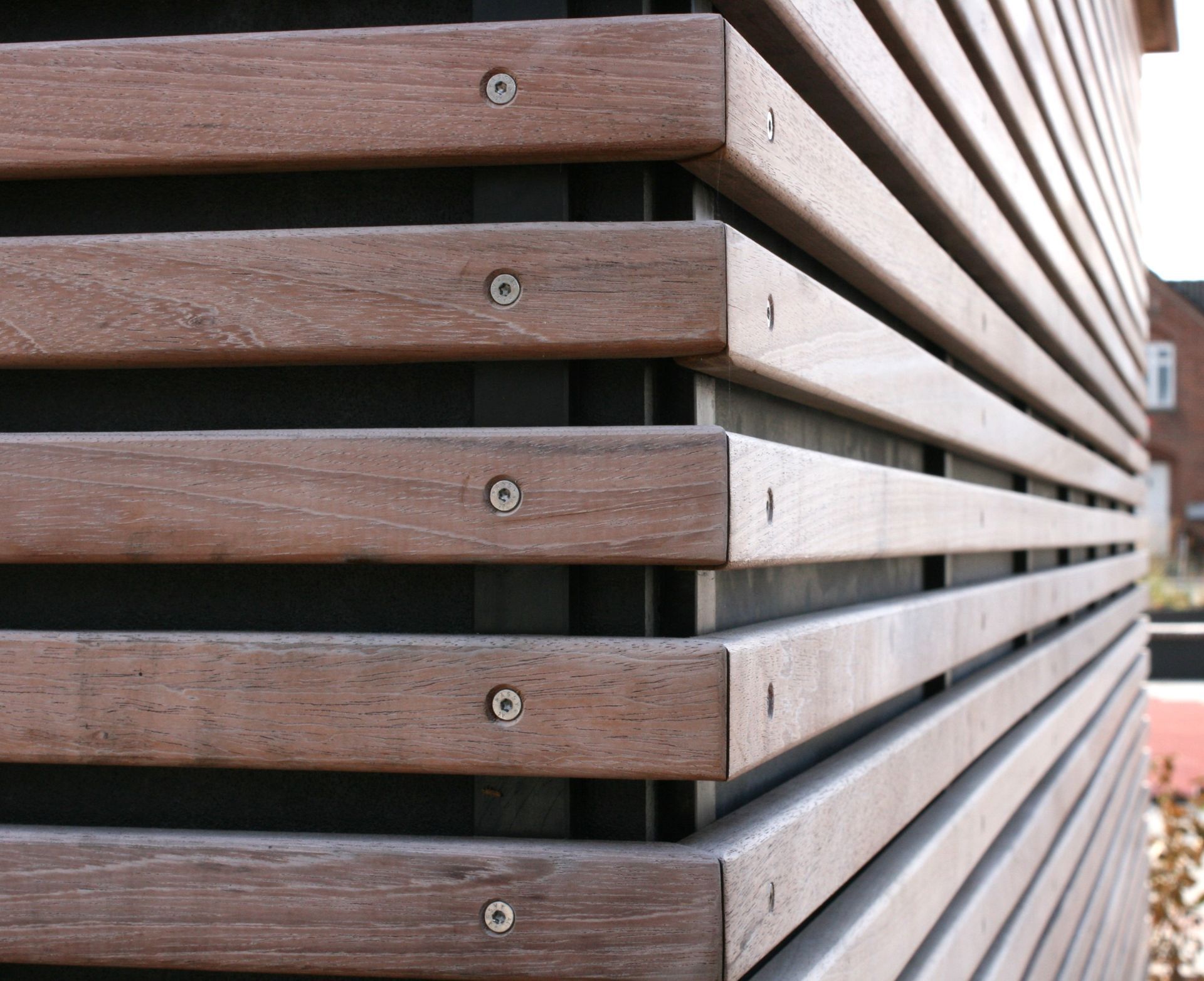 Et nærbillede af en trævæg med skruer på