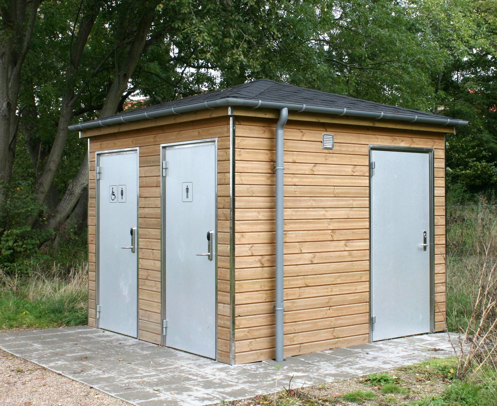 et skur med to grønne døre og et handicapskilt på døren