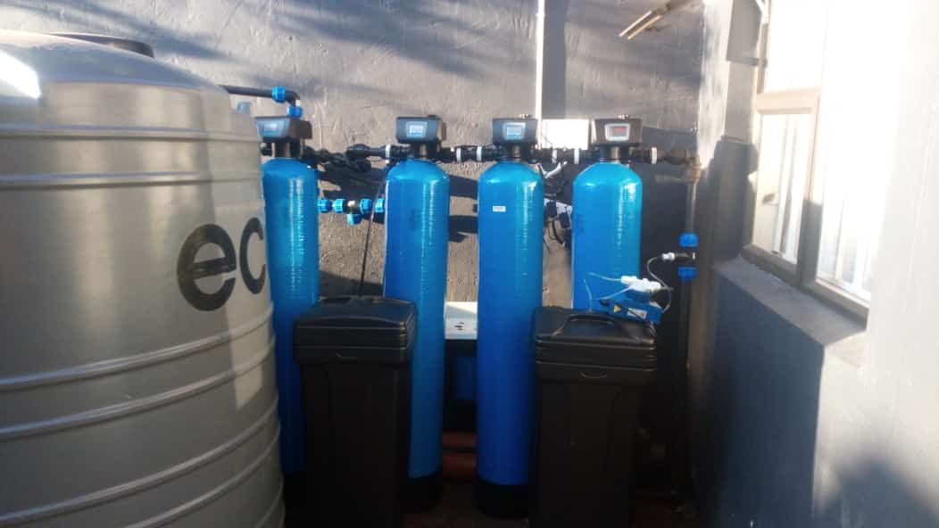 A row of blue water tanks are sitting next to each other in a room.