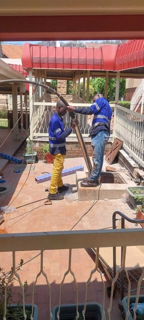 A couple of men are standing next to each other on a balcony.