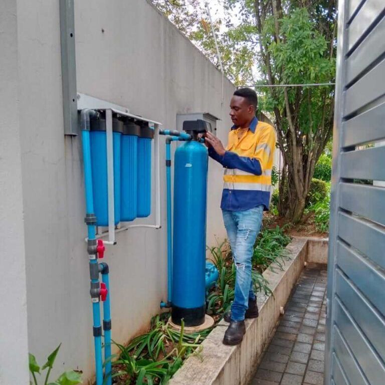 A man is working on a blue water filter