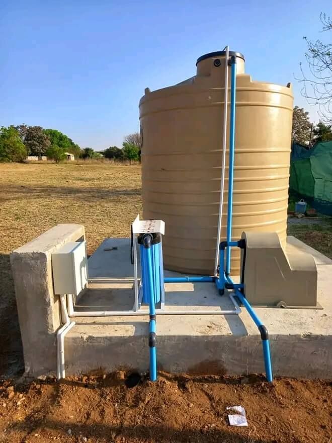 A large water tank is sitting on top of a concrete platform.