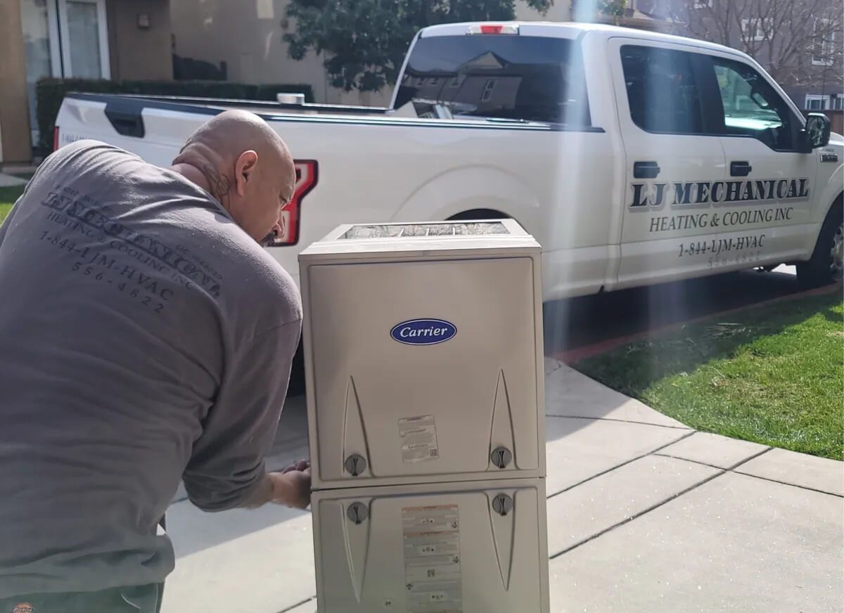 Man near a Carrier AC unit, beside a white truck with