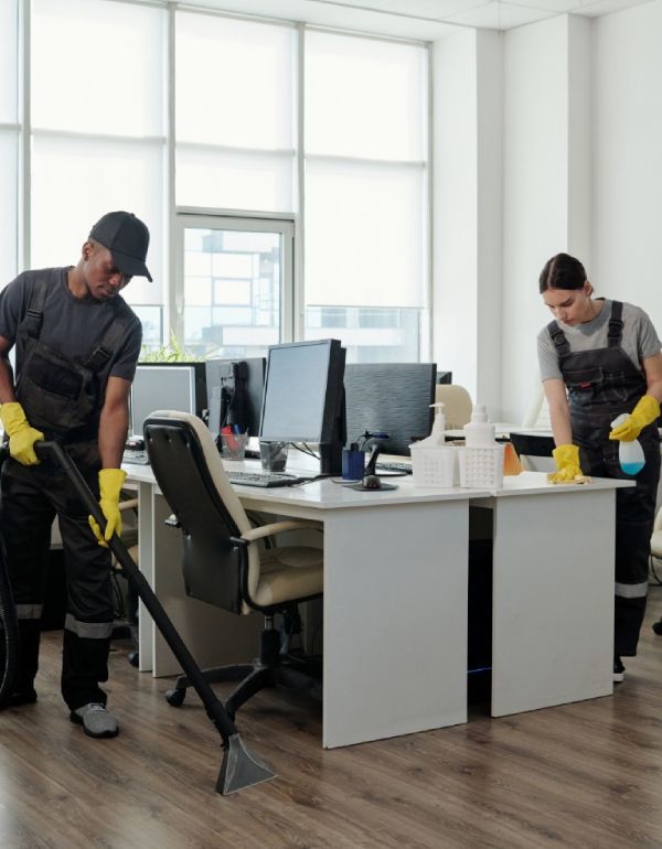Two people cleaning an office.