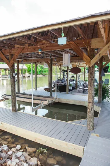 A dock with a covered area overlooking a body of water.