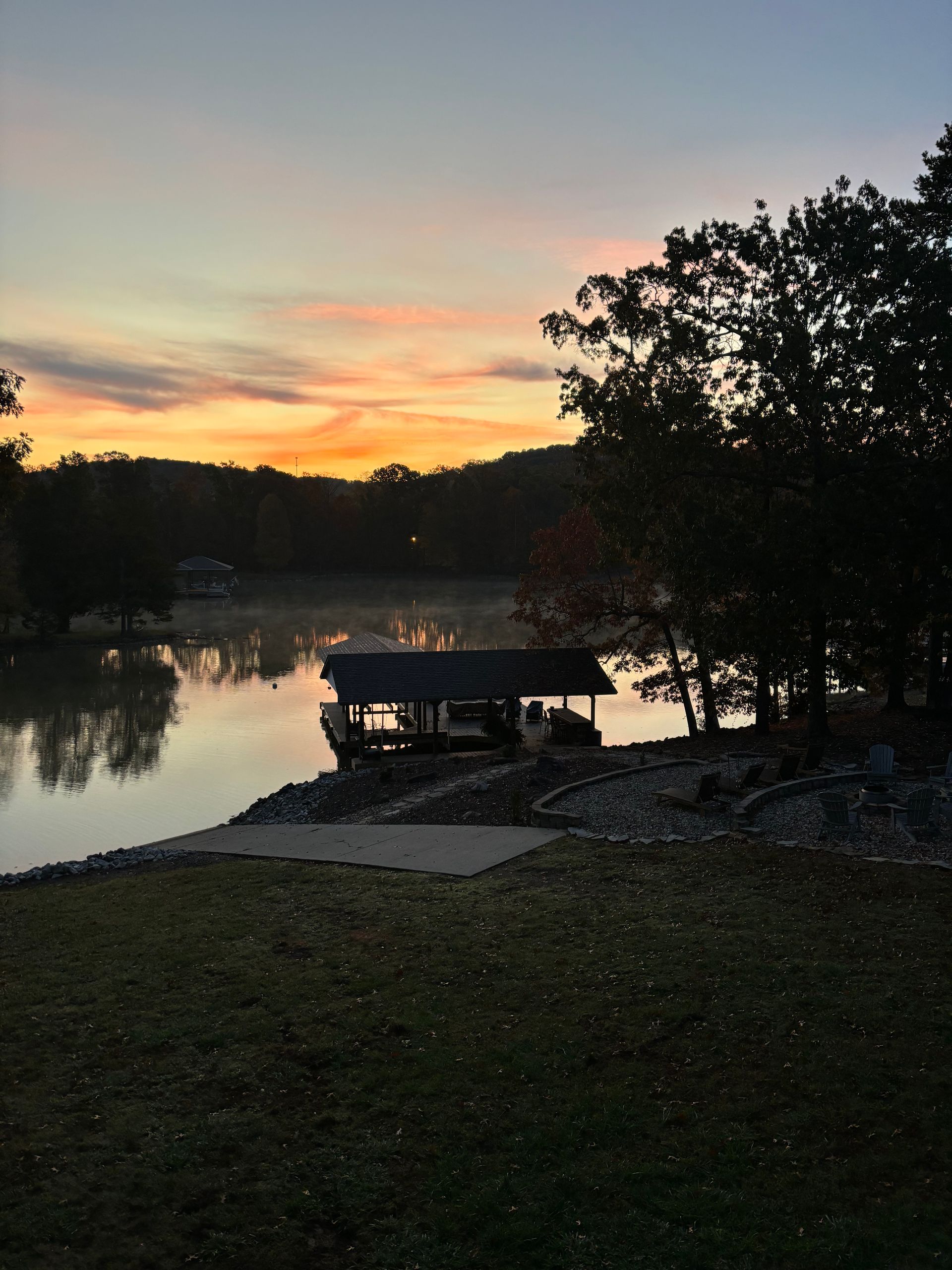 A sunset over a lake with a dock in the foreground
