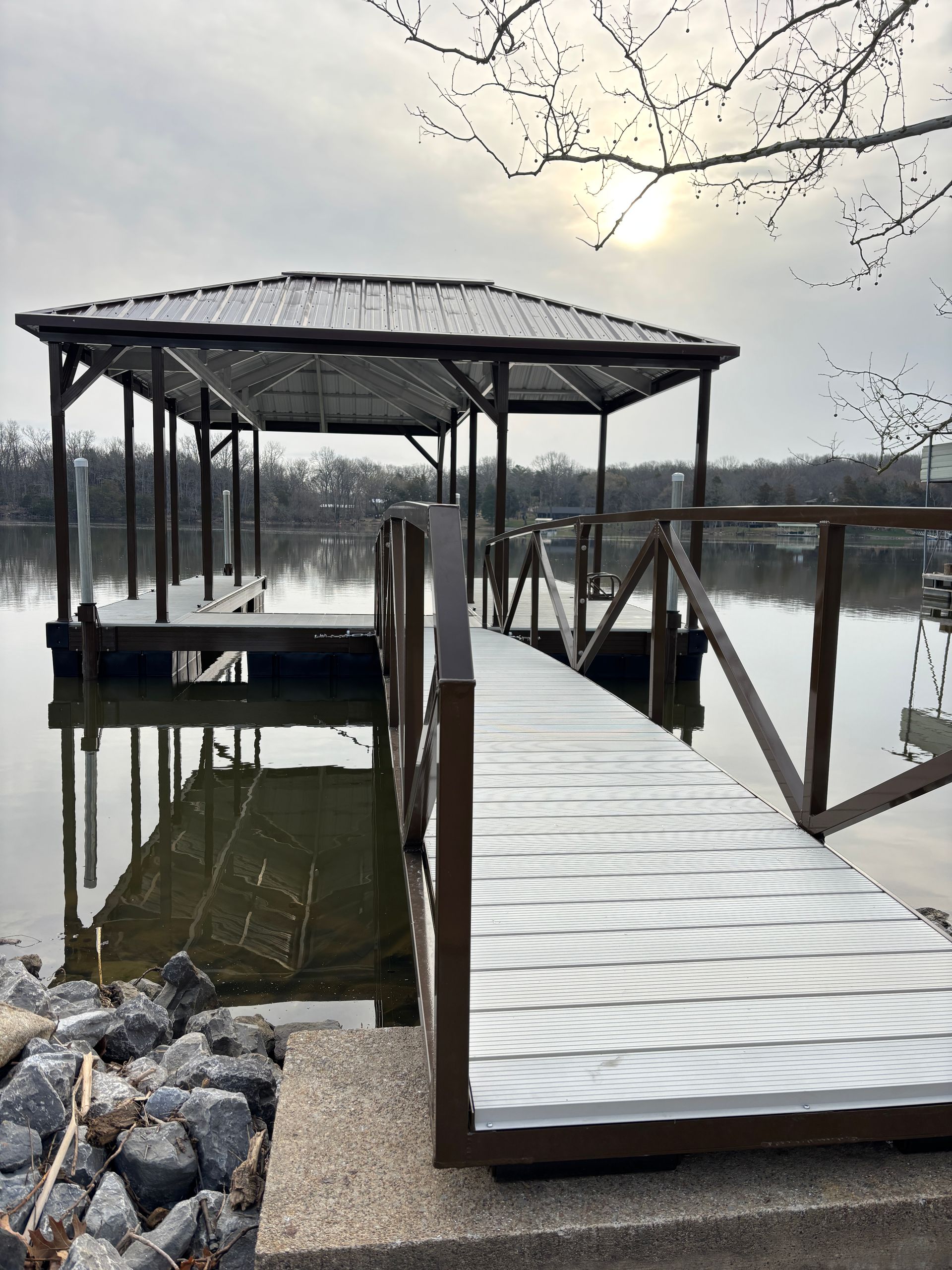 A wooden dock with a gazebo overlooking a lake.