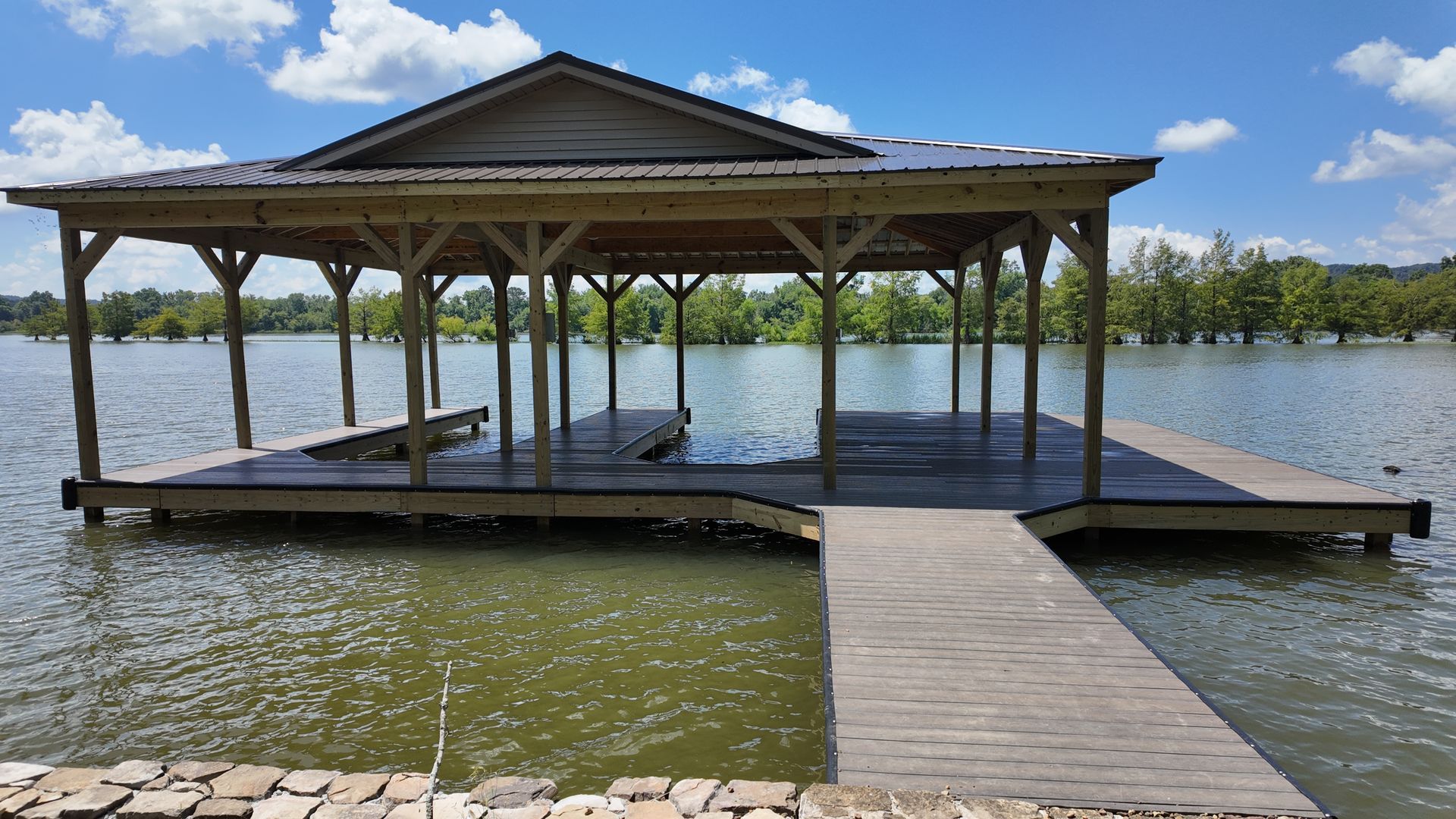 A wooden dock with a gazebo overlooking a lake.