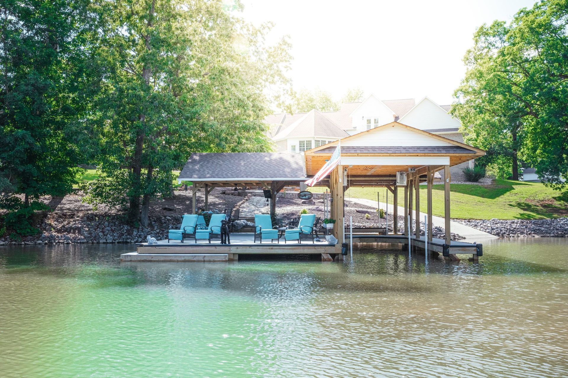 There is a dock with chairs on it in the middle of a lake.