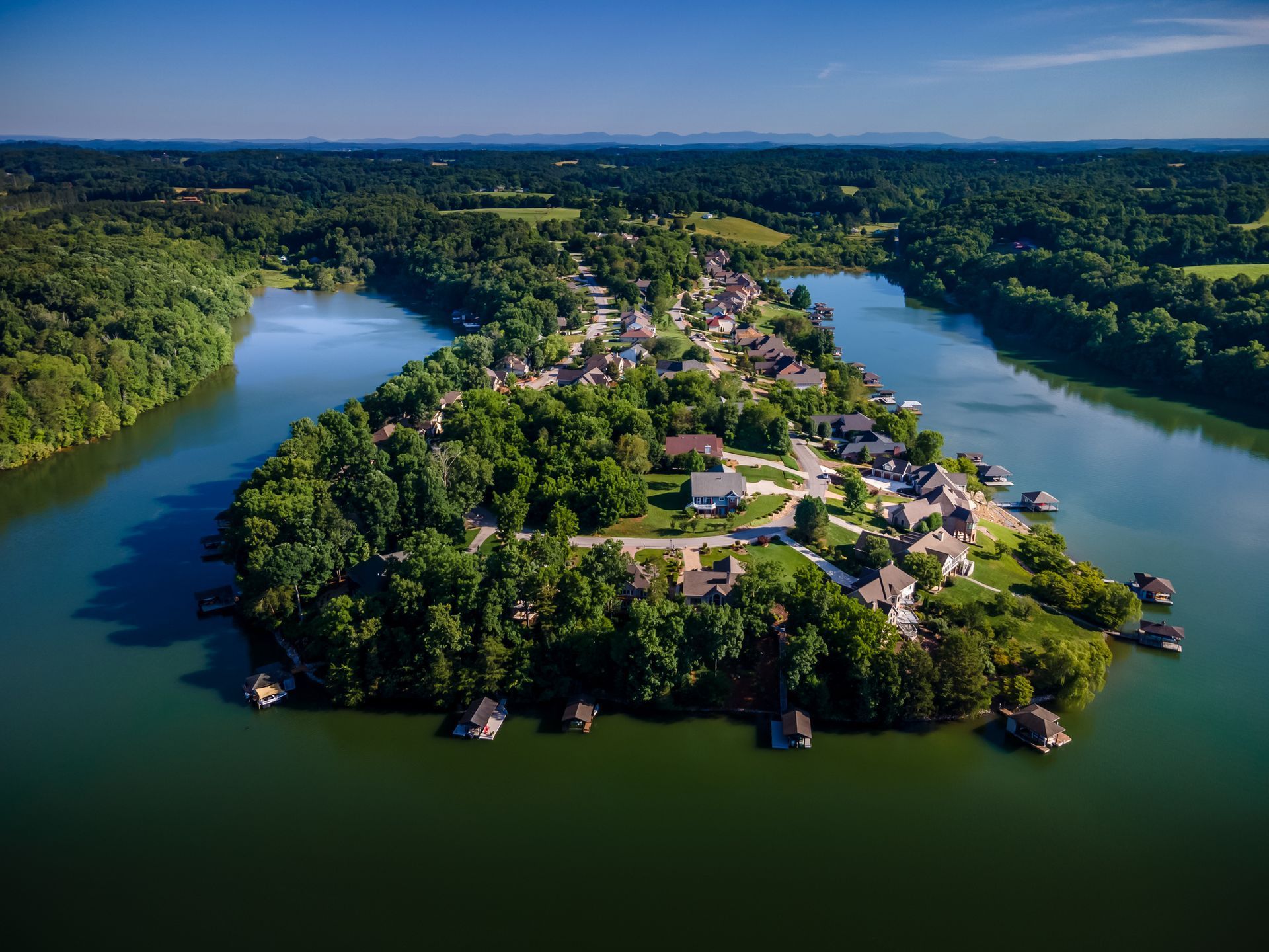 An aerial view of a small island in the middle of a lake surrounded by trees.