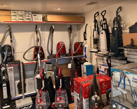 A blue and white vacuum cleaner is sitting on a shelf in a store.