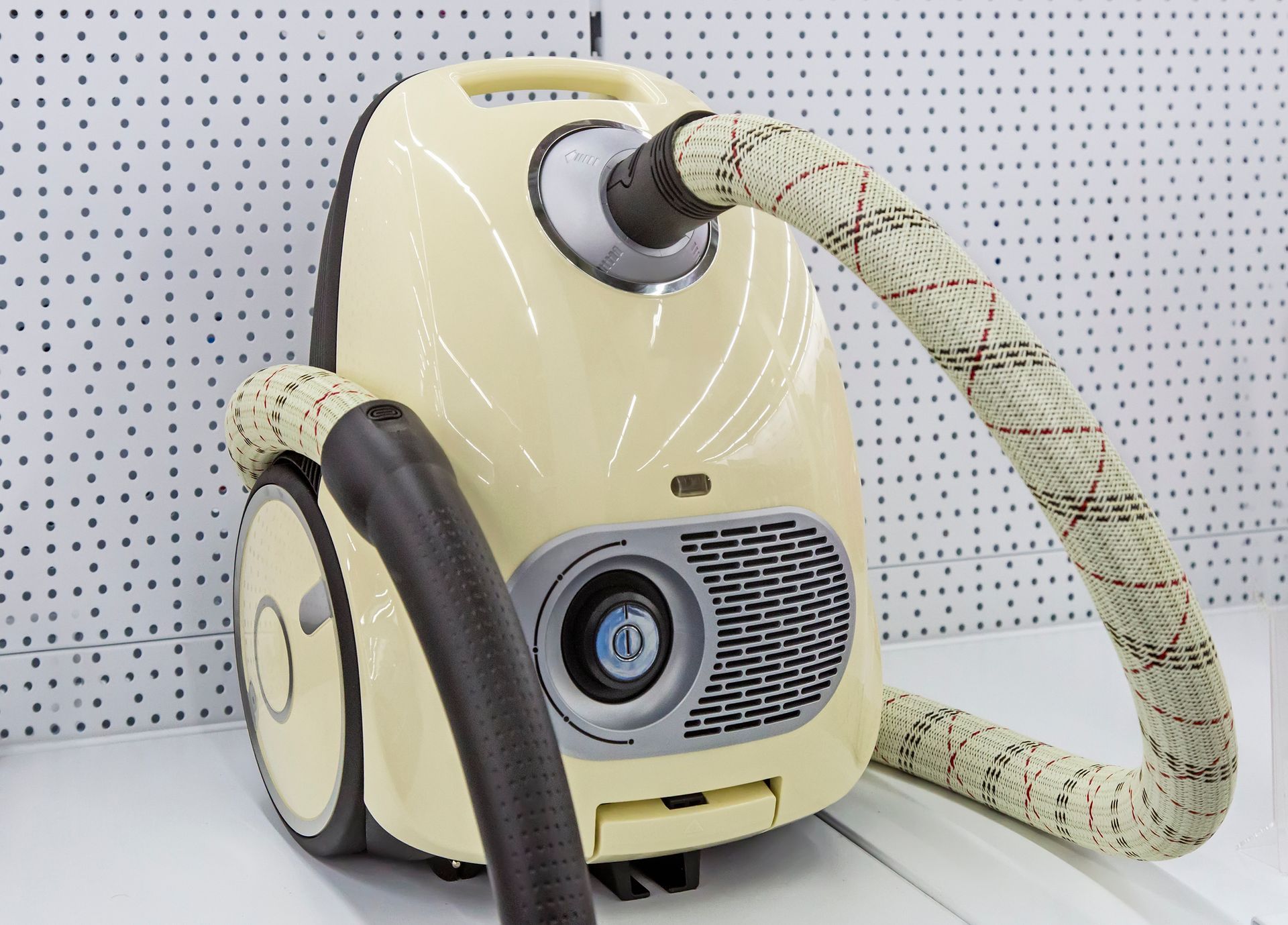 A yellow vacuum cleaner is sitting on a white table.