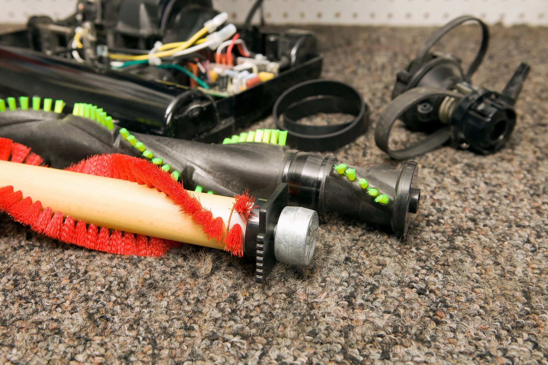 The parts of a vacuum cleaner are laying on the floor.