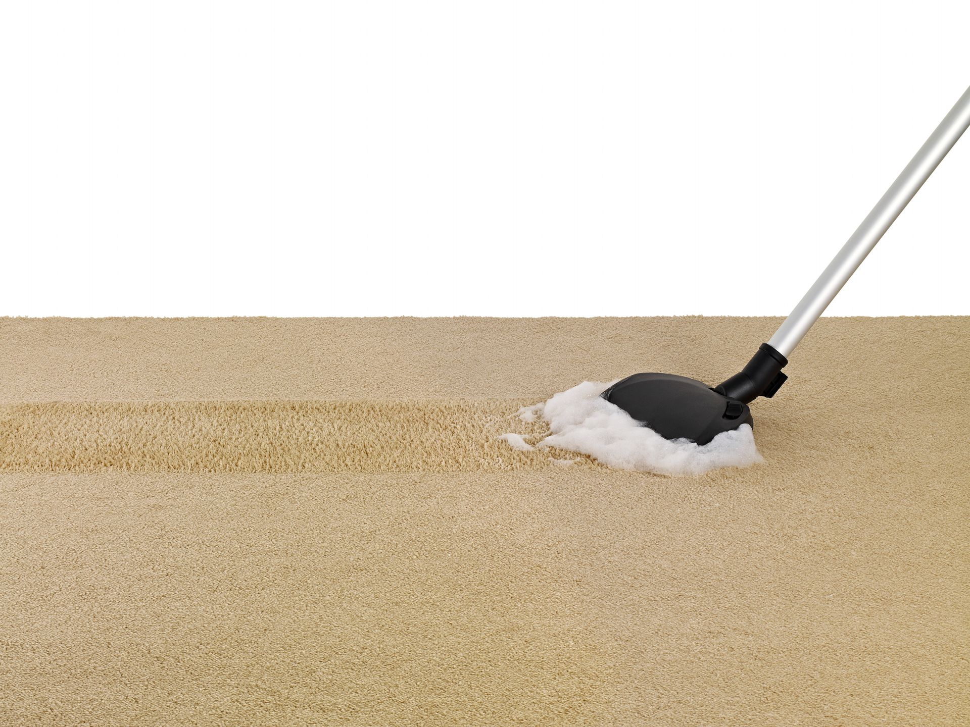 A mop is being used to clean a tan carpet.