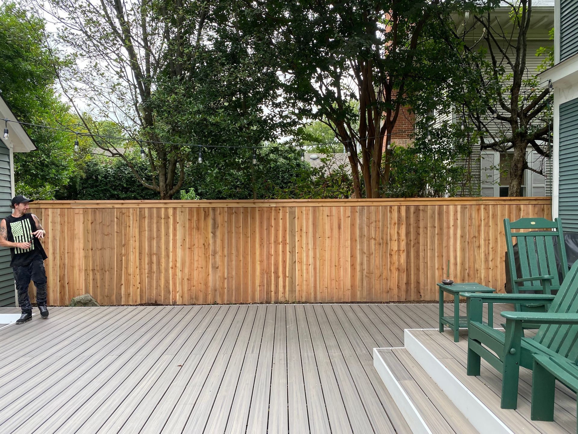 Composite deck with cedar fence behind it
