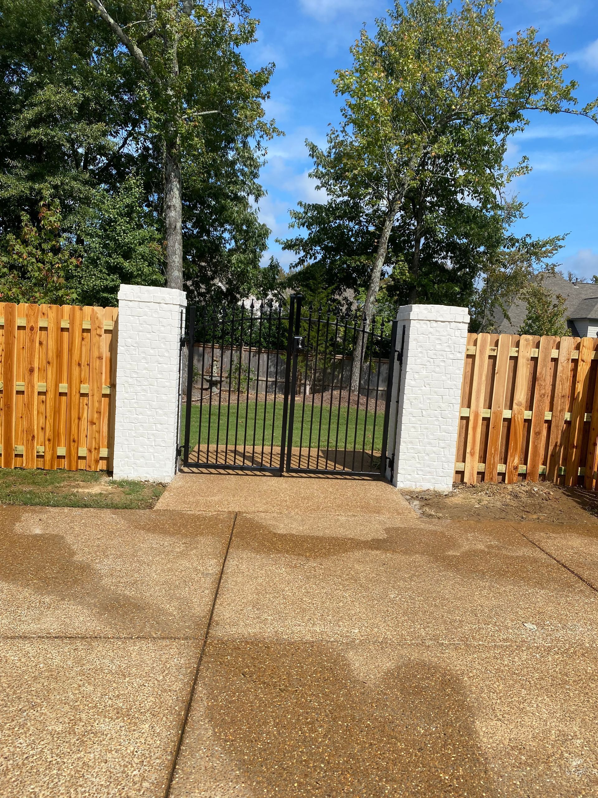 Cedar shadow box fence, painted brick columns and iron drive gate