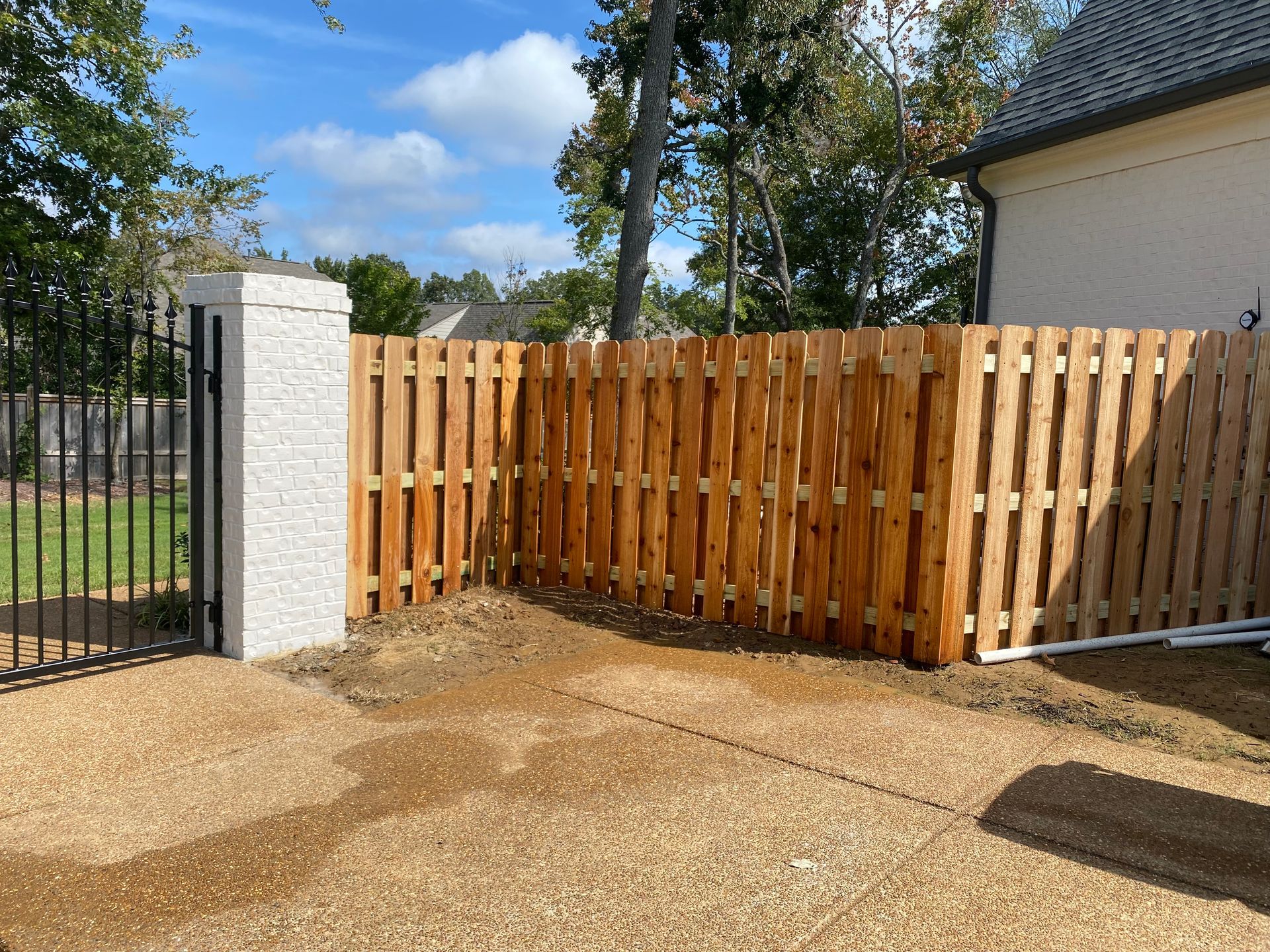 Cedar shadow box fence, painted brick columns and iron drive gate