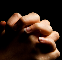 A close up of a person 's hands folded in prayer