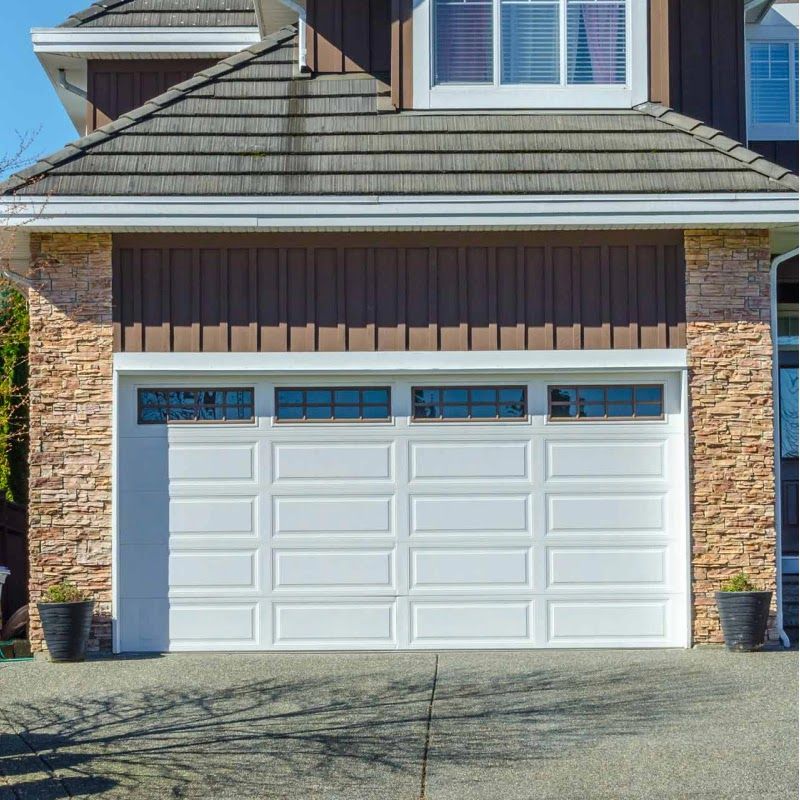 A large white garage door is on the side of a house.
