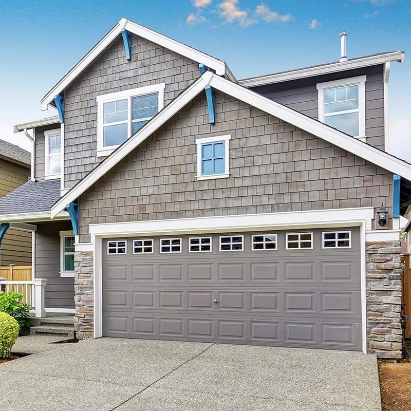 A large gray house with a large garage door