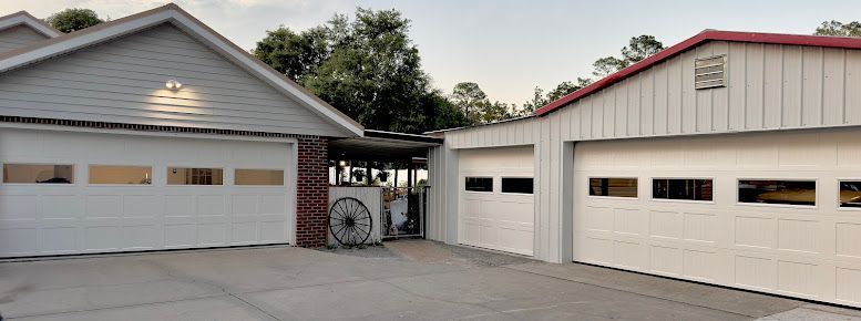 A house with three garage doors and a bicycle parked in front of it.