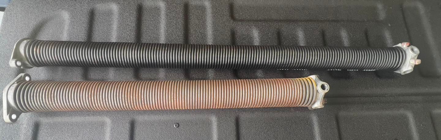 Two coil springs are sitting on top of a black surface.
