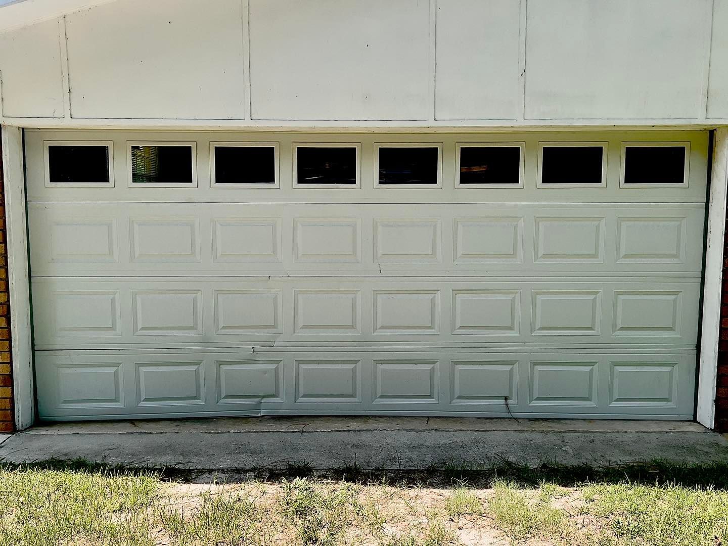 A white garage door with a lot of squares on it.