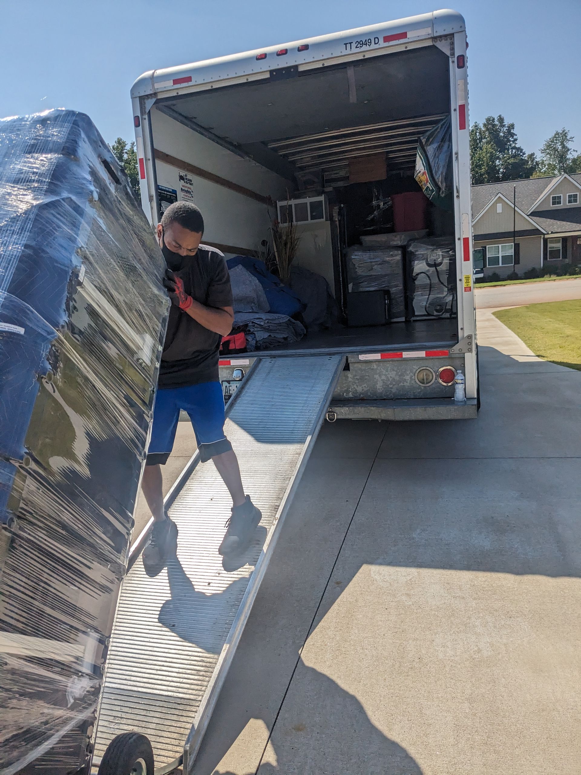A man is loading a couch into a moving truck.