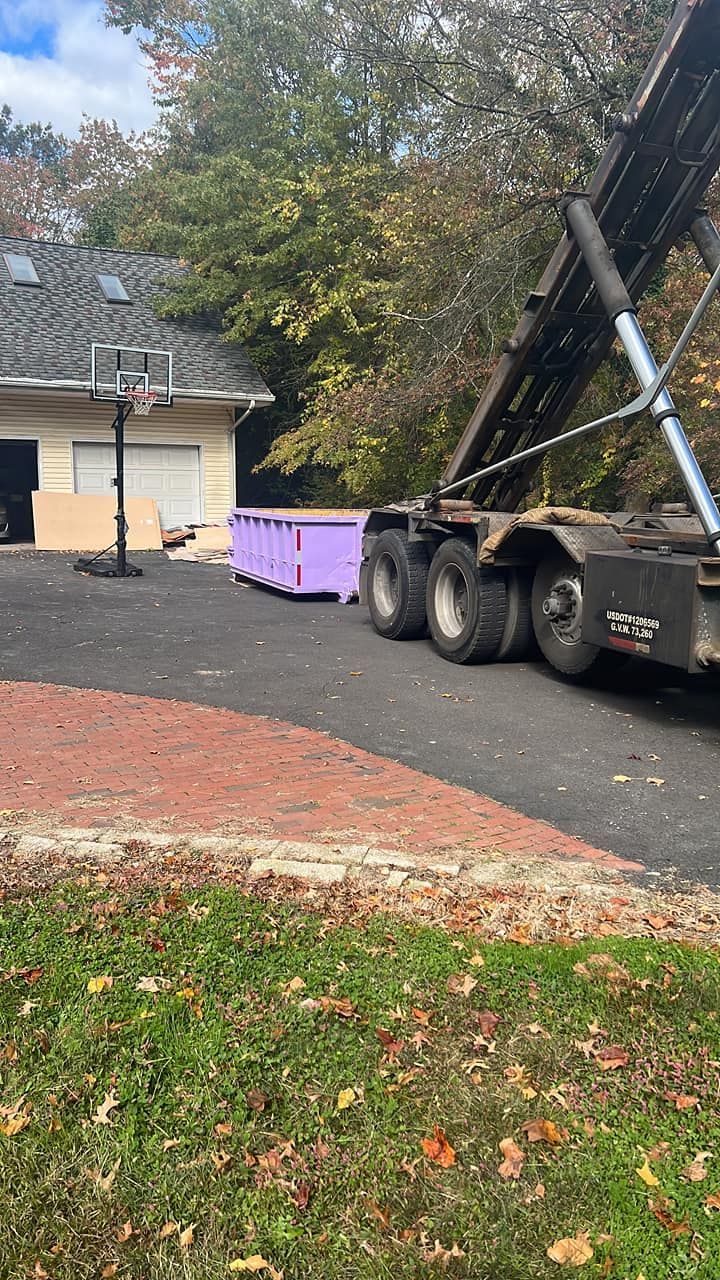 Red dumpster overflowing with construction debris on a suburban street.
