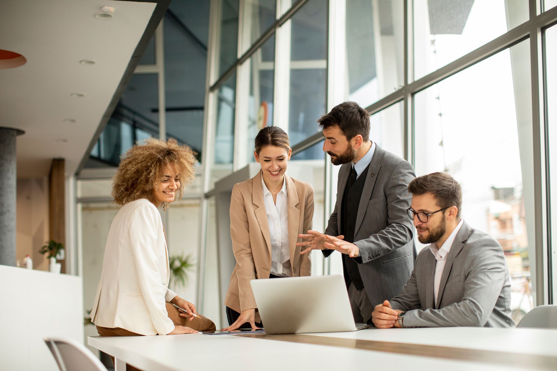 A group of business people are looking at a laptop computer.