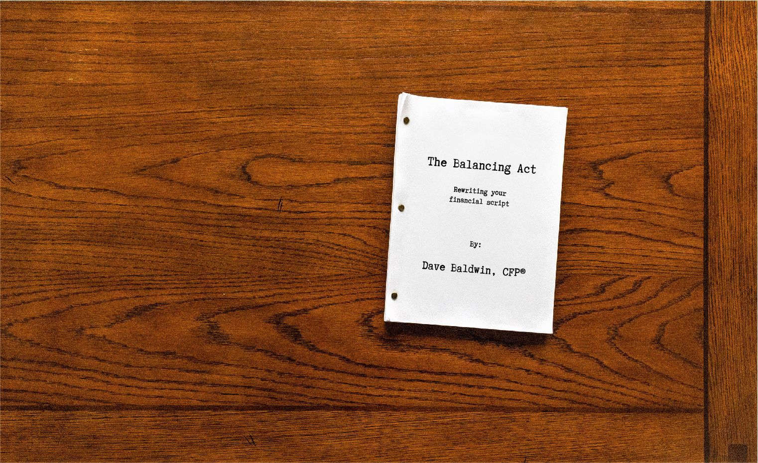 A small book is sitting on a wooden table.