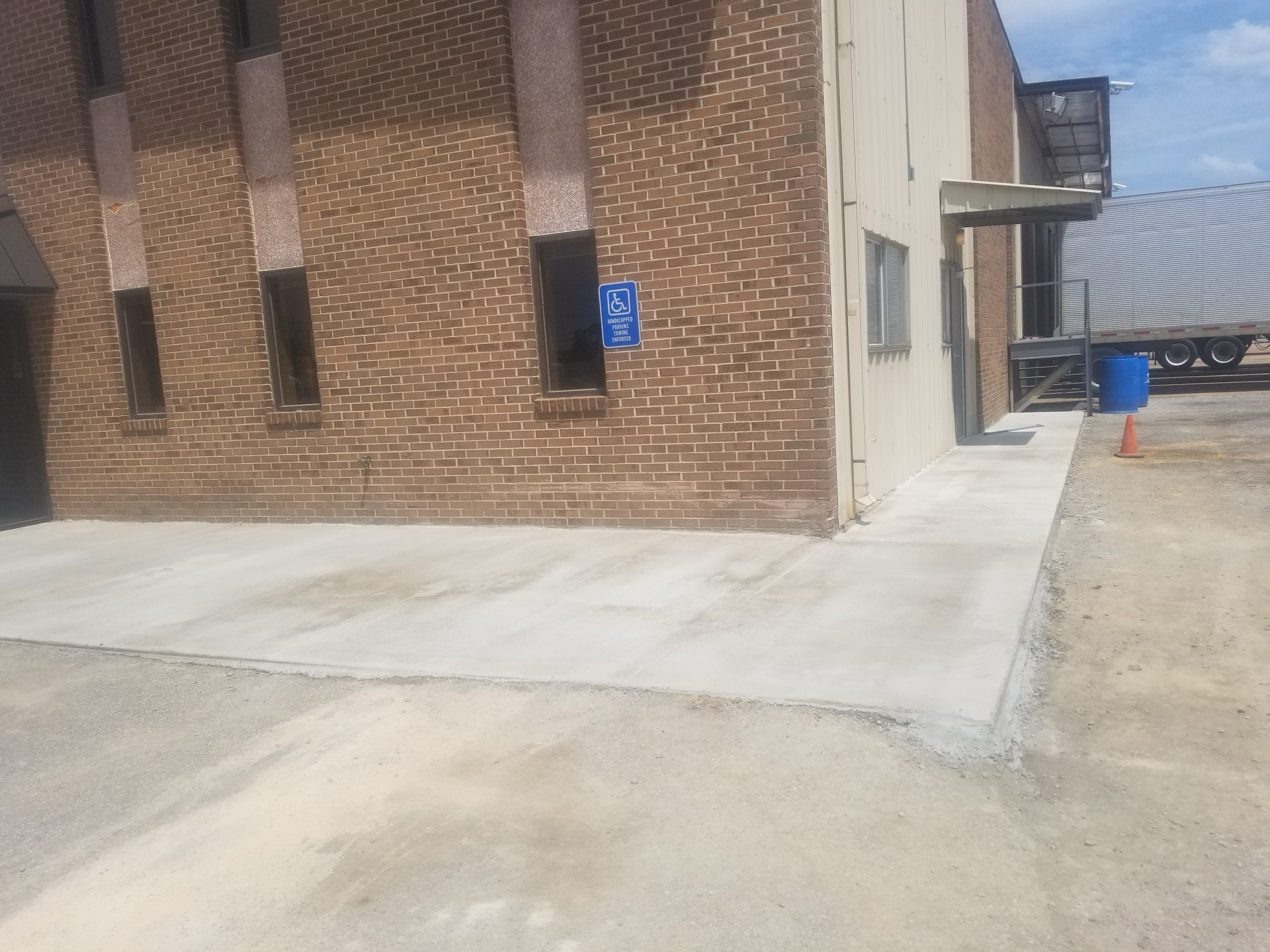 A brick building with a concrete walkway in front of it.