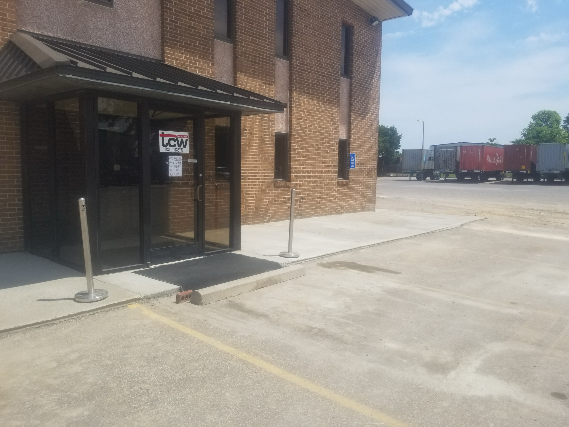 A brick building with a parking lot in front of it