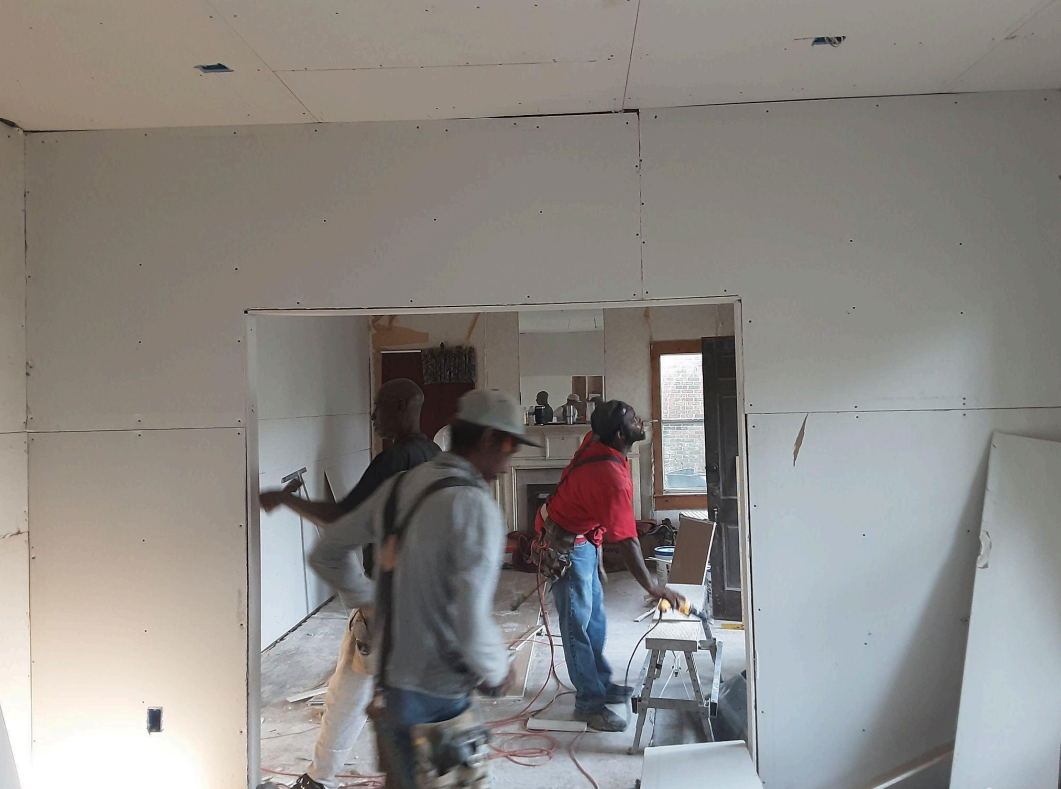 A group of construction workers are working in a room