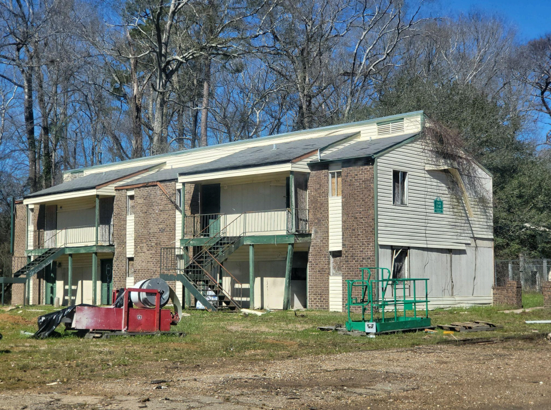 A large apartment building with a red truck parked in front of it.