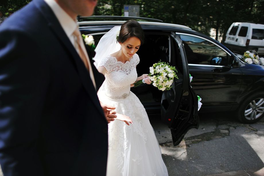 Una sposa e uno sposo stanno scendendo da un'auto.
