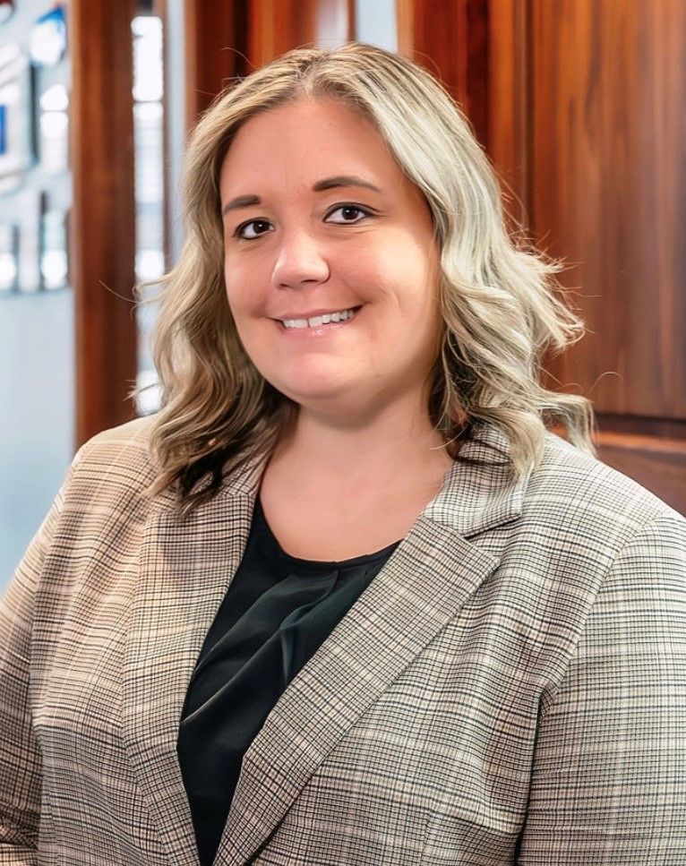 A woman with long blonde hair is smiling for the camera