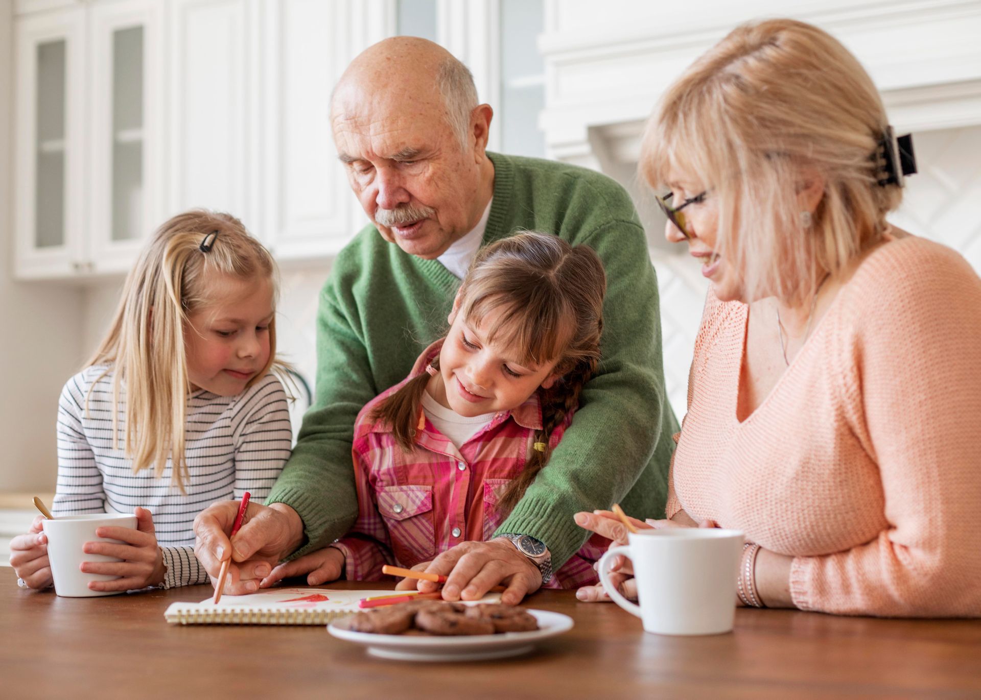 A family is sitting at a table drawing together.