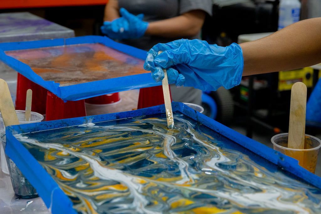 Epoxy resin contractors learning how to add color to epoxy resin with a practice slab in an epoxy resin training course.