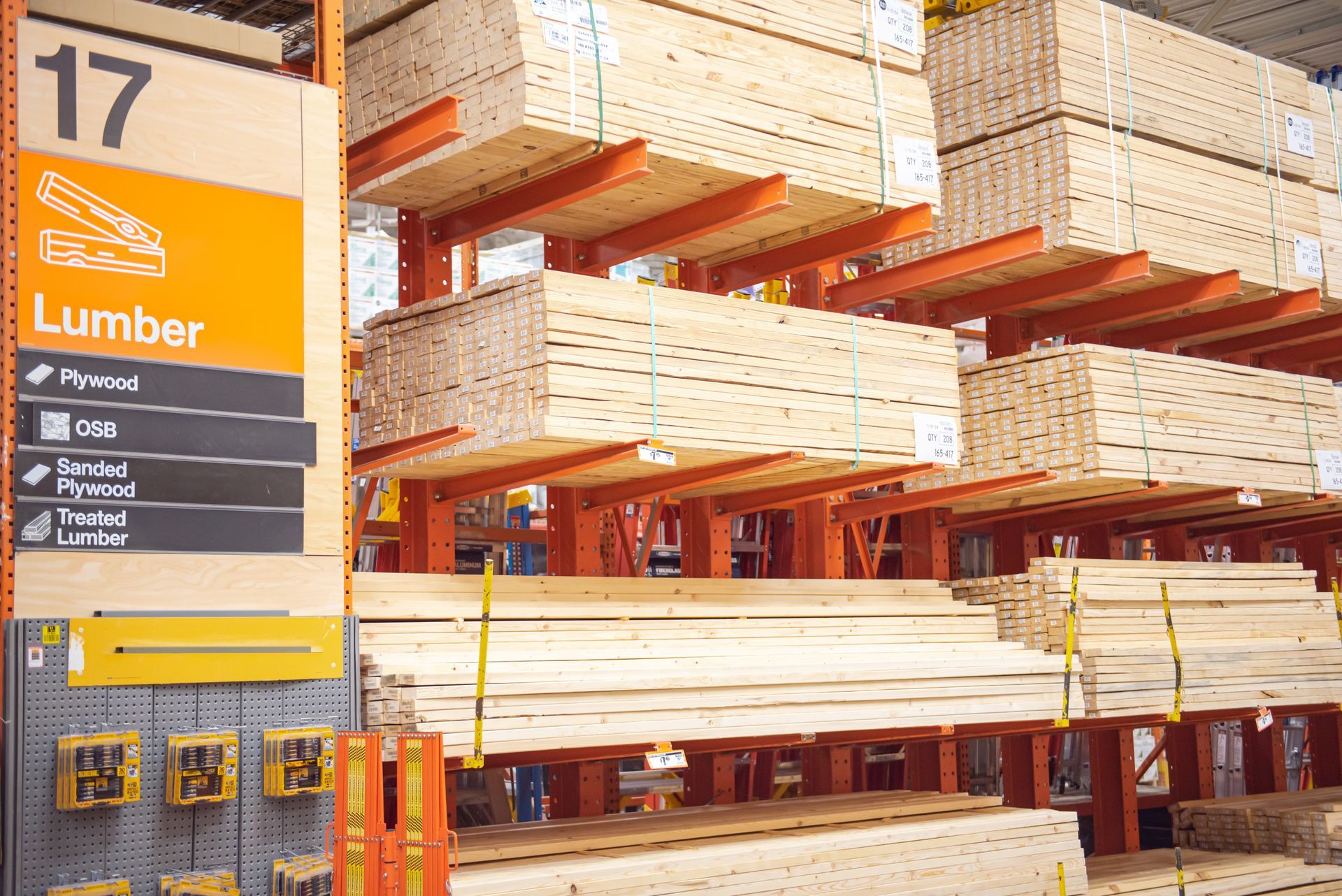 A Home Depot aisle sign labeled 17 Lumber with shelves of stacked wood panels and lumber boards. A Home Depot aisle sign labeled 17 Lumber with shelves of stacked wood panels and lumber boards.