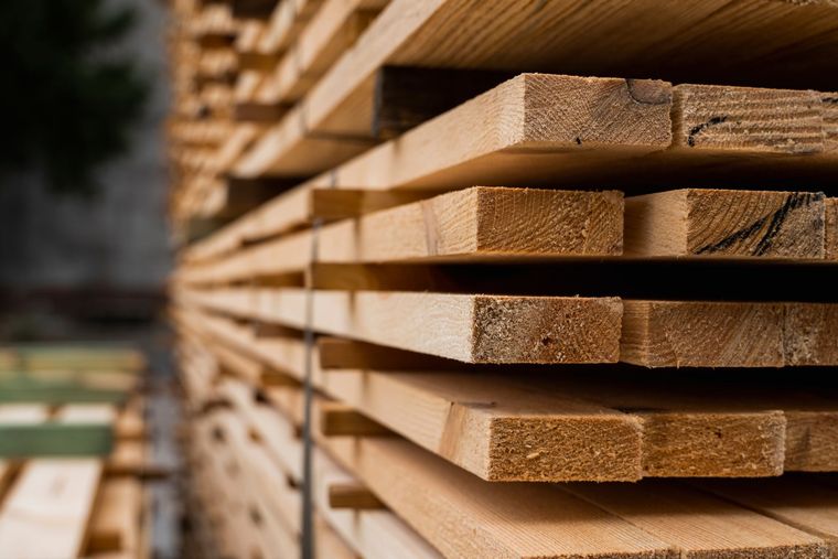 Stacked layers of light-brown wooden planks arranged in a receding perspective.