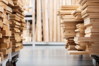 Two carts filled with stacked lumber in a warehouse aisle.