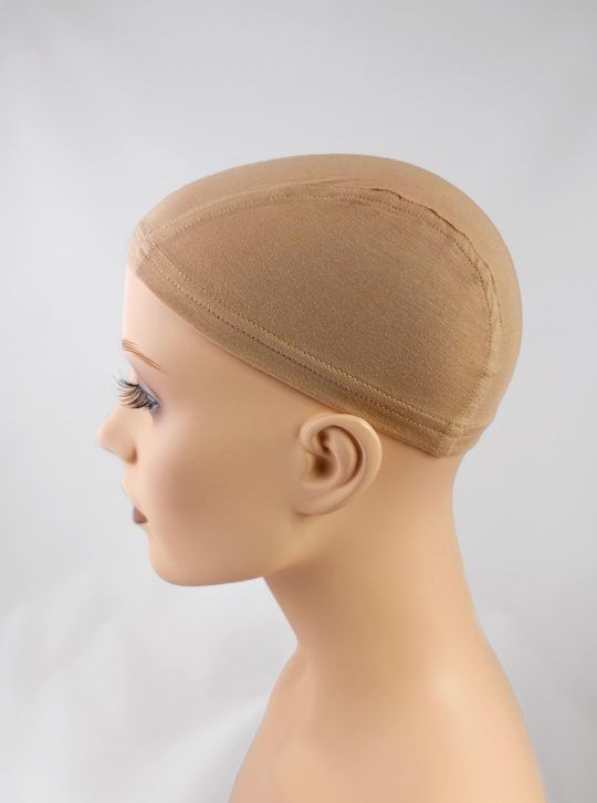 Mannequin head wearing a tan wig cap, side view against a white background.