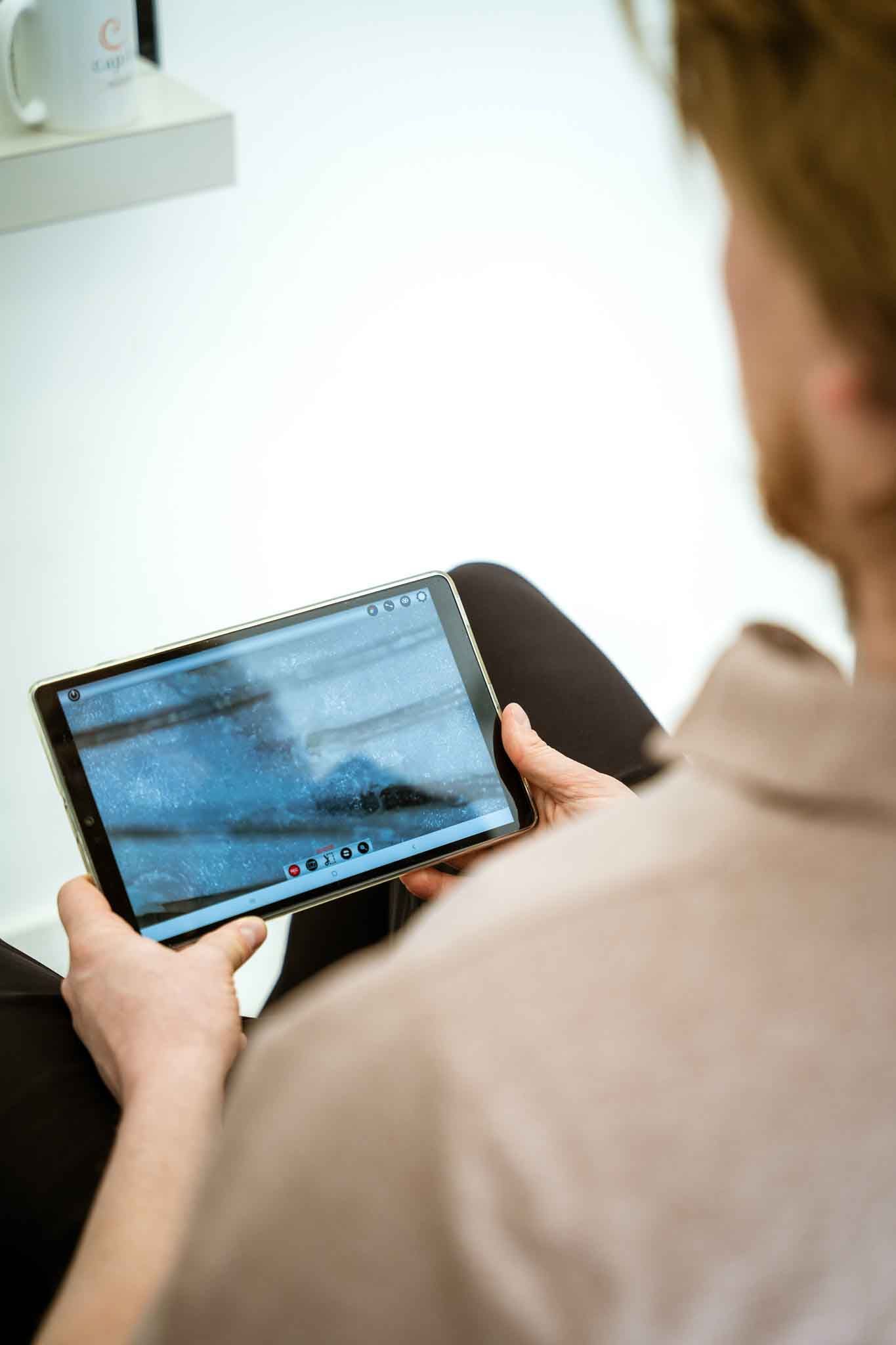 Une double porte en bois turquoise encadrée de bougainvillées rose vif sur la façade en pierre d'un bâtiment.