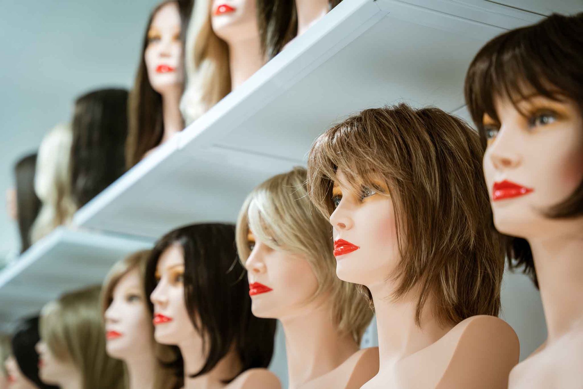 Une double porte en bois turquoise encadrée de bougainvillées rose vif sur la façade en pierre d'un bâtiment.