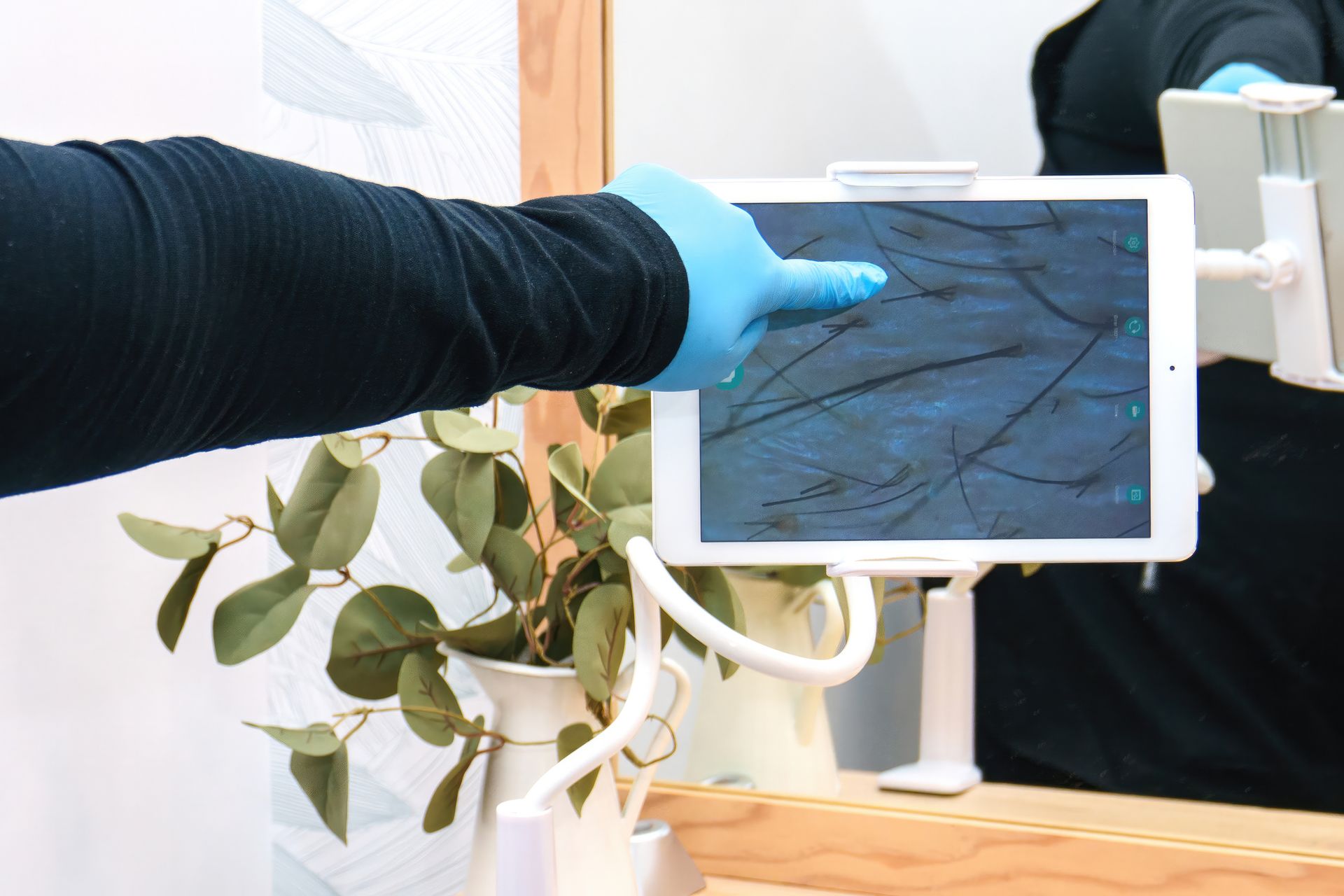 Person having scalp treatment with a handheld device, light hair, white setting.